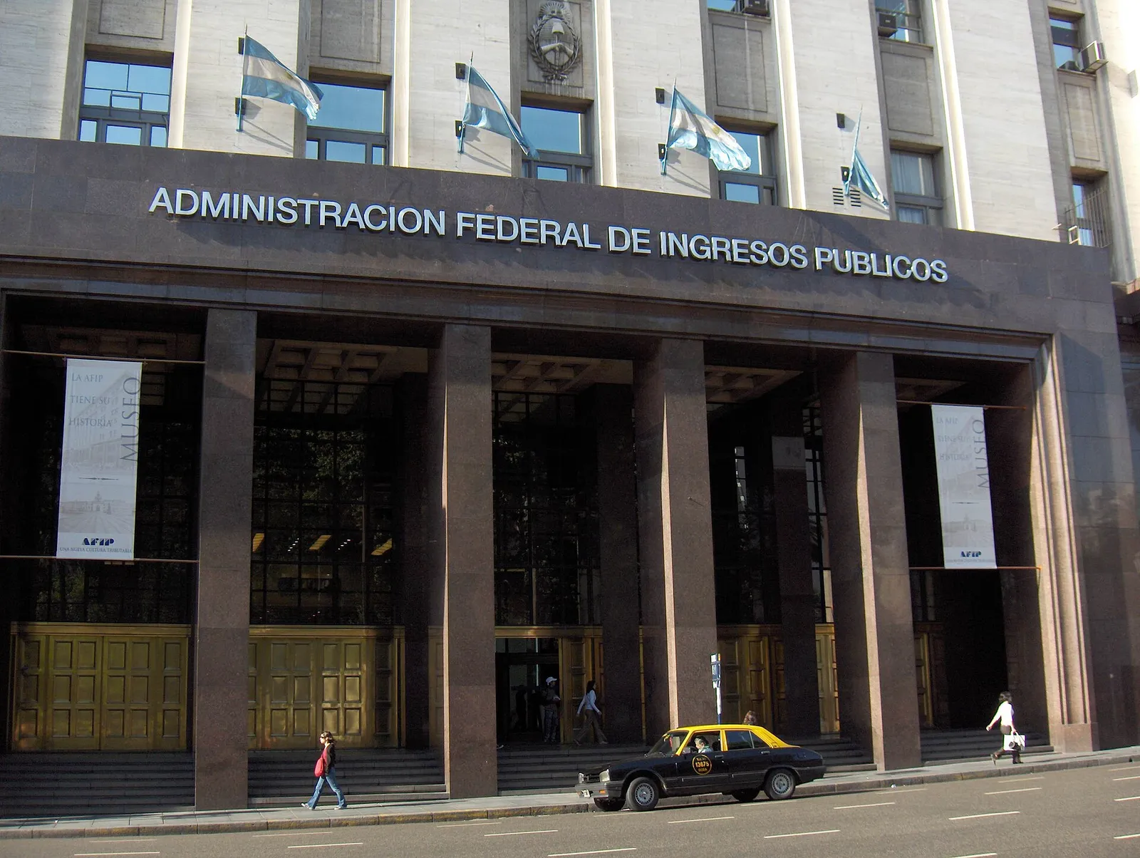 Entrada del edificio central de ARCA, con el cartel de su nombre anterior, Administración Federal de Ingresos Públicos, y banderas argentinas
