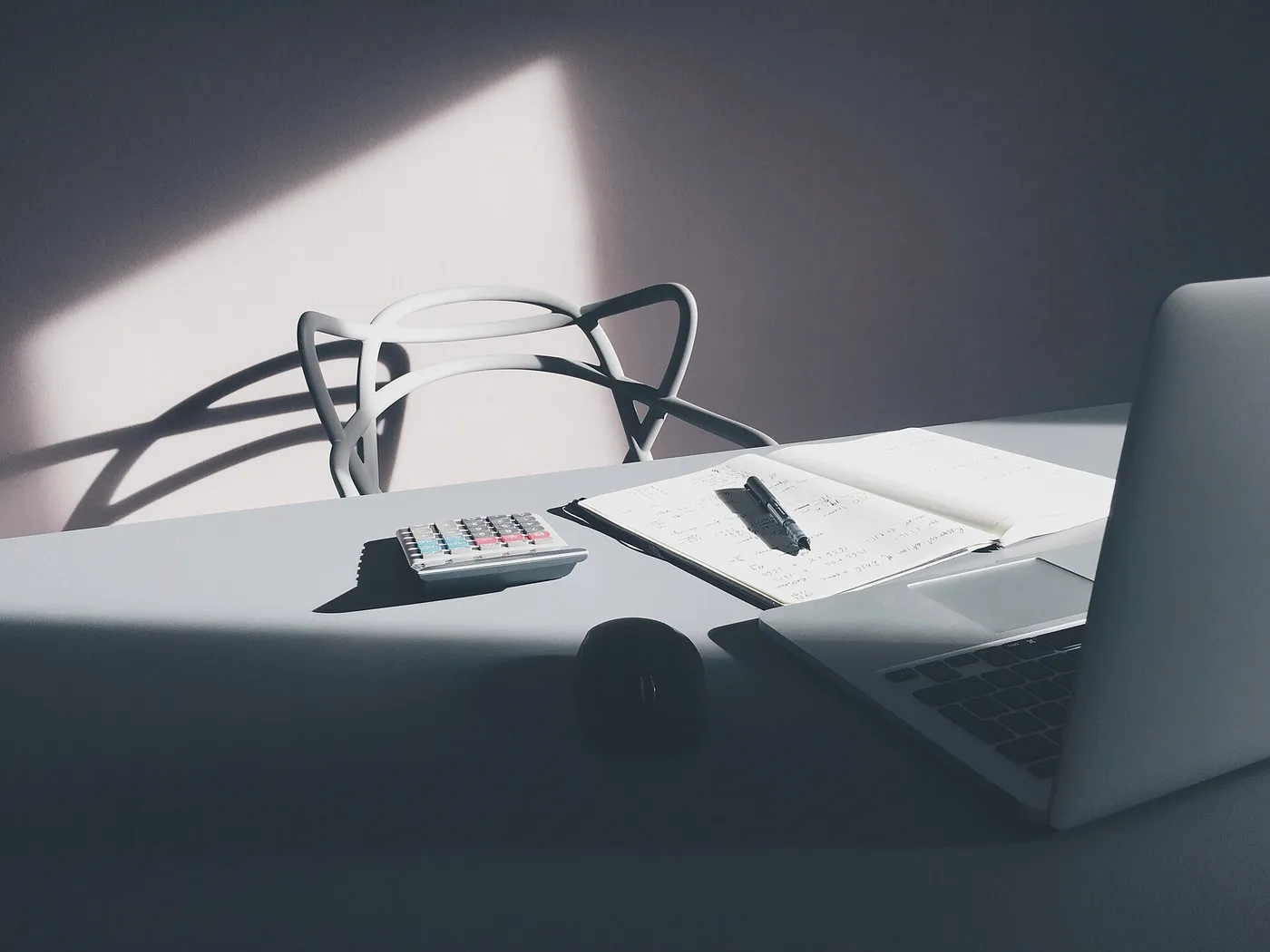 Escritorio con una calculadora, un cuaderno de notas y una computadora portátil